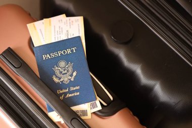 Biletlerle birlikte Amerika Birleşik Devletleri pasaportu havaalanının bekleme salonunda duran turistik bavulun üzerinde yatıyor. Dünya çapında seyahat ve uluslararası turizm kavramı