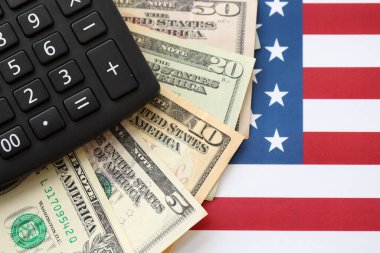 Amerikan doları para ve hesap makinesi Amerikan bayrağına yakın. Para yatırımı konsepti ve vergi ödeme