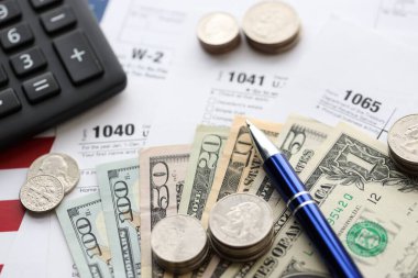 Amerikan Doları. Para banknotları ve vergi formundaki kalem ve hesap makineli paralar boş. Muhasebe ve vergi ödeme dönemi kavramı