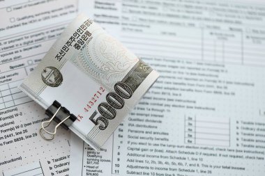 Kuzey Kore büyük miktarlarda para kazandı. Masada vergi formları var. Muhasebe ve vergilendirme kavramı