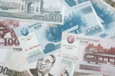 Kuzey Kore büyük miktarlarda para kazandı. Beyaz renkli masada yatıyor. Yakın plan. Finans ve bankacılık kavramı