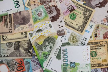 Farklı para birimlerinden ve ülkelerden yüklü miktarda para. Uluslararası nakitin çeşitli arka planında büyük bir yığın var.