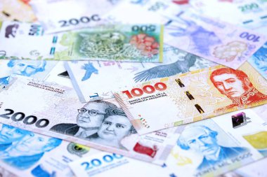 Arjantin pezosu büyük miktarlarda para beyaz masada yakın planda yatıyor. Finans ve bankacılık kavramı