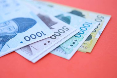 Güney Kore büyük miktarlarda para kazandı. Kırmızı renkli masada yatıyor. Yakın plan. Finans ve bankacılık kavramı