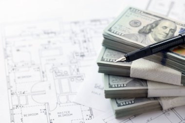 Kalemle birlikte yüklü miktarda Amerikan doları banknotları ve konut projesinin planları yakın plan. Yatırım ve inşaat projesi kavramı