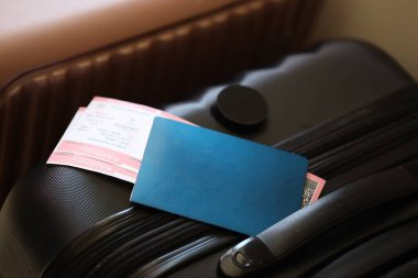 Biletli boş pasaport havaalanı bekleme salonundaki turistik bavulun üzerinde duruyor. Dünya çapında seyahat ve uluslararası turizm kavramı