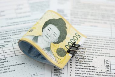 Güney Kore büyük miktarlarda para kazandı. Masada vergi formları var. Muhasebe ve vergilendirme kavramı