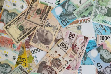 Farklı para birimlerinden ve ülkelerden yüklü miktarda para. Uluslararası nakitin çeşitli arka planında büyük bir yığın var.