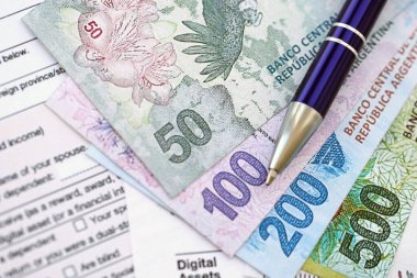 Arjantin pezosu büyük miktarlarda para masasında duruyor. Kalem ve vergi formları da yakında. Finans ve bankacılık kavramı