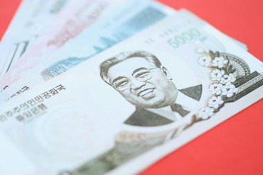 Kuzey Kore büyük miktarlarda para kazandı. Yakın plan kırmızı masada yatıyor. Finans ve bankacılık kavramı