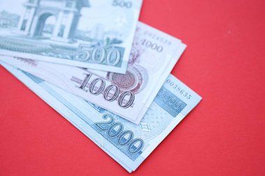 Kuzey Kore büyük miktarlarda para kazandı. Yakın plan kırmızı masada yatıyor. Finans ve bankacılık kavramı