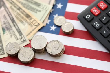 Amerikan doları para ve hesap makinesi Amerikan bayrağına yakın. Para yatırımı konsepti ve vergi ödeme