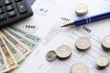 Amerikan Doları. Para banknotları ve vergi formundaki kalem ve hesap makineli paralar boş. Muhasebe ve vergi ödeme dönemi kavramı