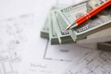 Kalemle birlikte yüklü miktarda Amerikan doları banknotları ve konut projesinin planları yakın plan. Yatırım ve inşaat projesi kavramı