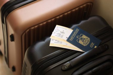 Biletli Birleşik Arap Emirlikleri pasaportu havaalanındaki bekleme salonunun yakınındaki turistik bavulda yatıyor. Dünya çapında seyahat ve uluslararası turizm kavramı
