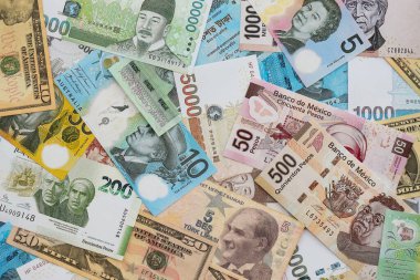 Farklı para birimlerinden ve ülkelerden yüklü miktarda para. Uluslararası nakitin çeşitli arka planında büyük bir yığın var.