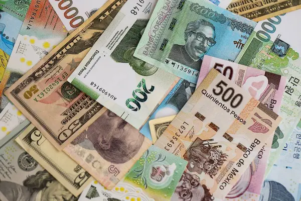 Farklı para birimlerinden ve ülkelerden yüklü miktarda para. Uluslararası nakitin çeşitli arka planında büyük bir yığın var.