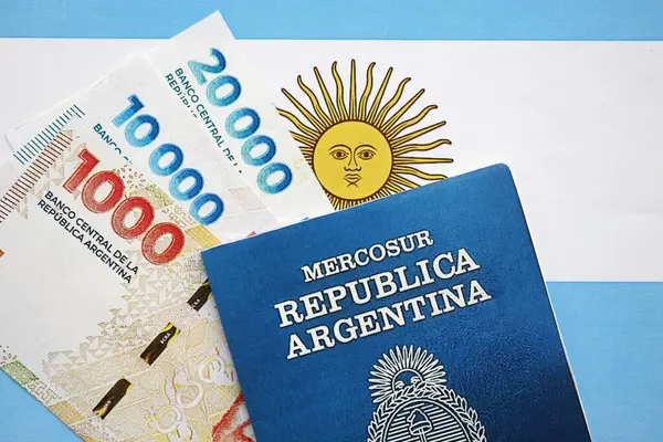 Arjantin pezosu büyük miktarda para ve pasaport Arjantin bayrağına yakın duruyor. Finans ve bankacılık kavramı