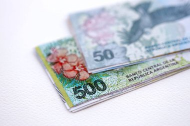 Arjantin pezosu büyük miktarlarda para beyaz masada yakın planda yatıyor. Finans ve bankacılık kavramı