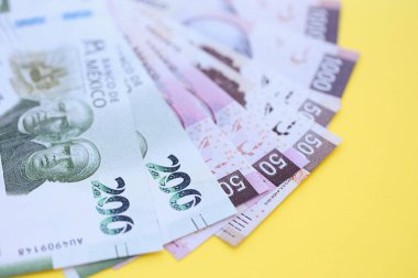 Meksika pezosu faturaları büyük miktarlarda sarı renkli masaya yakın duruyor. Finans ve bankacılık kavramı