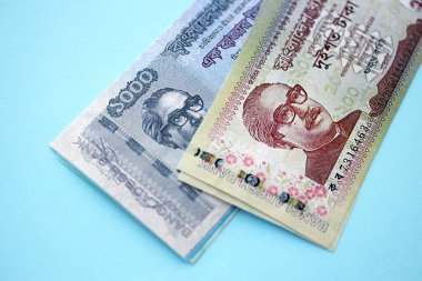 Bangladeşli para banknotları büyük miktarlarda deniz mavisi renkli masaların üzerinde. Finans ve bankacılık kavramı