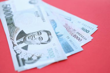 Kuzey Kore büyük miktarlarda para kazandı. Yakın plan kırmızı masada yatıyor. Finans ve bankacılık kavramı
