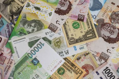 Farklı para birimlerinden ve ülkelerden yüklü miktarda para. Uluslararası nakitin çeşitli arka planında büyük bir yığın var.