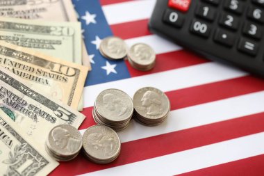 Amerikan doları para ve hesap makinesi Amerikan bayrağına yakın. Para yatırımı konsepti ve vergi ödeme