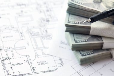 Kalemle birlikte yüklü miktarda Amerikan doları banknotları ve konut projesinin planları yakın plan. Yatırım ve inşaat projesi kavramı