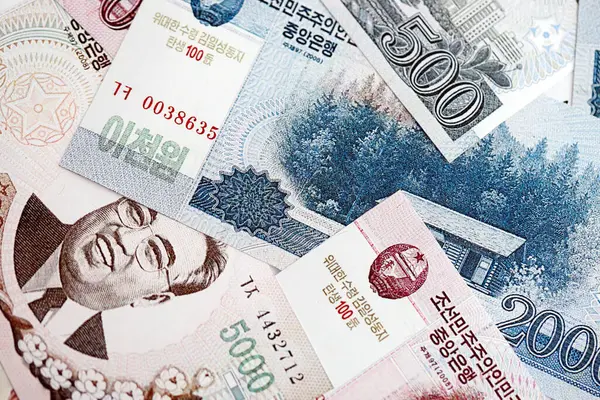 Kuzey Kore büyük miktarlarda para kazandı. Beyaz renkli masada yatıyor. Yakın plan. Finans ve bankacılık kavramı