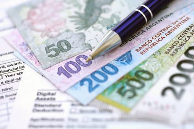 Arjantin pezosu büyük miktarlarda para masasında duruyor. Kalem ve vergi formları da yakında. Finans ve bankacılık kavramı