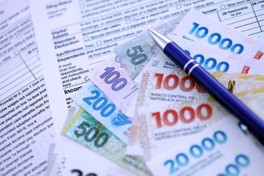 Arjantin pezosu büyük miktarlarda para masasında duruyor. Kalem ve vergi formları da yakında. Finans ve bankacılık kavramı