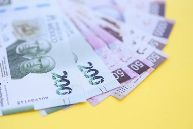 Meksika pezosu faturaları büyük miktarlarda sarı renkli masaya yakın duruyor. Finans ve bankacılık kavramı