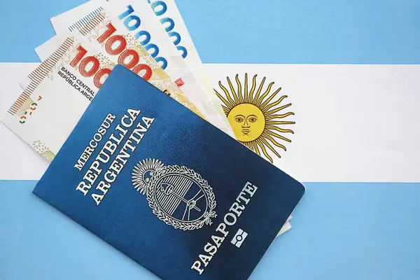 Arjantin pezosu büyük miktarda para ve pasaport Arjantin bayrağına yakın duruyor. Finans ve bankacılık kavramı