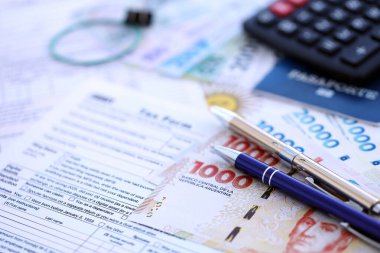 Arjantin Pezosu 'nun para faturaları kalem, hesap makinesi, pasaport ve vergi formlarıyla dolu. Finans ve bankacılık kavramı