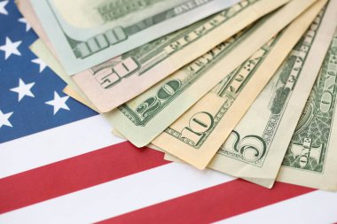 Amerikan doları banknotları ve Amerikan bayrağı kapanıyor. Para yatırımı konsepti ve vergi ödeme