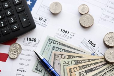 Amerikan Doları. Para banknotları ve vergi formundaki kalem ve hesap makineli paralar boş. Muhasebe ve vergi ödeme dönemi kavramı