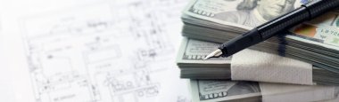 Kalemle birlikte yüklü miktarda Amerikan doları banknotları ve konut projesinin planları yakın plan. Yatırım ve inşaat projesi kavramı