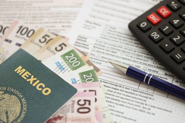 Meksika pezosu para faturaları kalem, hesap makinesi, pasaport ve vergi formlarıyla dolu. Finans ve bankacılık kavramı