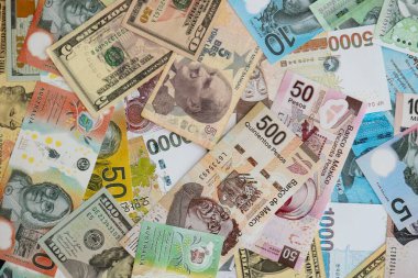 Farklı para birimlerinden ve ülkelerden yüklü miktarda para. Uluslararası nakitin çeşitli arka planında büyük bir yığın var.