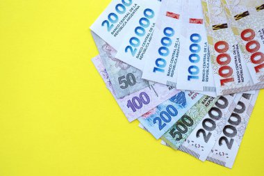 Arjantin pezosu büyük miktarlarda banknotlar sarı renkli masaya yakın duruyor. Finans ve bankacılık kavramı