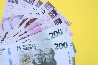 Meksika pezosu faturaları büyük miktarlarda sarı renkli masaya yakın duruyor. Finans ve bankacılık kavramı