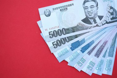 Kuzey Kore büyük miktarlarda para kazandı. Yakın plan kırmızı masada yatıyor. Finans ve bankacılık kavramı
