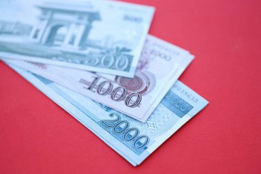 Kuzey Kore büyük miktarlarda para kazandı. Yakın plan kırmızı masada yatıyor. Finans ve bankacılık kavramı