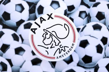 KYIV, UKRAINE - 23 Şubat 2025 AFC Ajax futbol kulübü rozeti futbol toplarının arka plan pankartında yatıyor