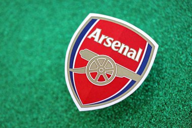 KYIV, UKRAINE - 23 Şubat 2025 Arsenal FC futbol kulübü rozeti zümrüt yeşili simli arka plan pankartıyla uzanır