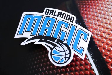 KYIV, UKRAINE - 23 Şubat 2025 Orlando Magic basketbol takımı rozeti basketbol topu arka plan pankartıyla yatıyor