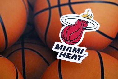 KYIV, UKRAINE - 23 Şubat 2025 Miami Heat basketbol takımı rozeti basketbol topu arka plan afişinde yatıyor