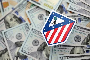 KYIV, UKRAINE - 23 Şubat 2025 Atletico de Madrid futbol kulübü rozeti yüzlük banknotların üzerinde yatıyor