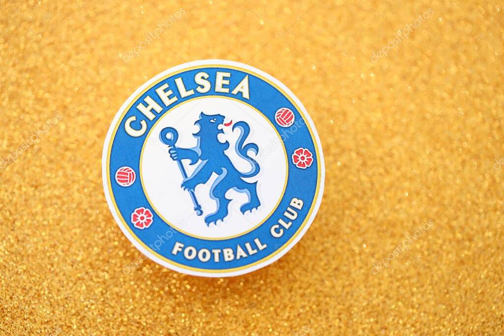 KYIV, UKRAINE - FEBRUARY 23, 2025 Chelsea FC football club badge lies on golden yellow glitter background banner